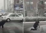 Мъж пълзи по заледена пешеходна пътека в Скопие