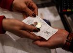Продавач в столичен приема евро банкноти от клиенти в магазин за хранителни стоки в София. БГНЕС/ЕПА