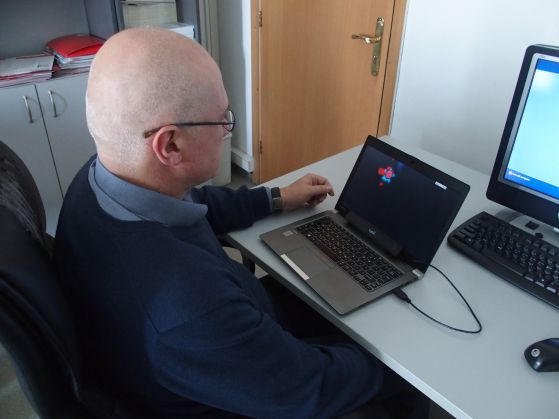 Доцент Морис Гринберг демонстрира контрола с поглед върху компютъра. Устройството е включено с USB към лаптопа.