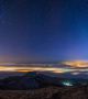 Посипано със звезди нощно небе, а светлините от далечни градове блестят под ниско надвиснали облаци в тази снимка, направена в района на Пятигорск, Русия.  Снимка: International Earth&Sky Photo Contest